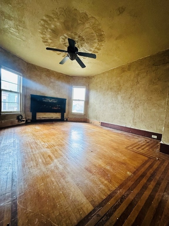 unfurnished living room with hardwood / wood-style flooring and ceiling fan