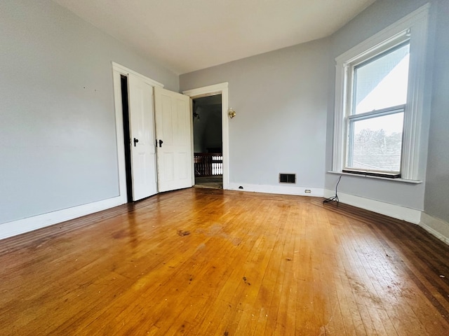 unfurnished room with wood-type flooring