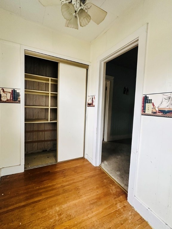 interior space featuring ceiling fan, hardwood / wood-style floors, and a closet