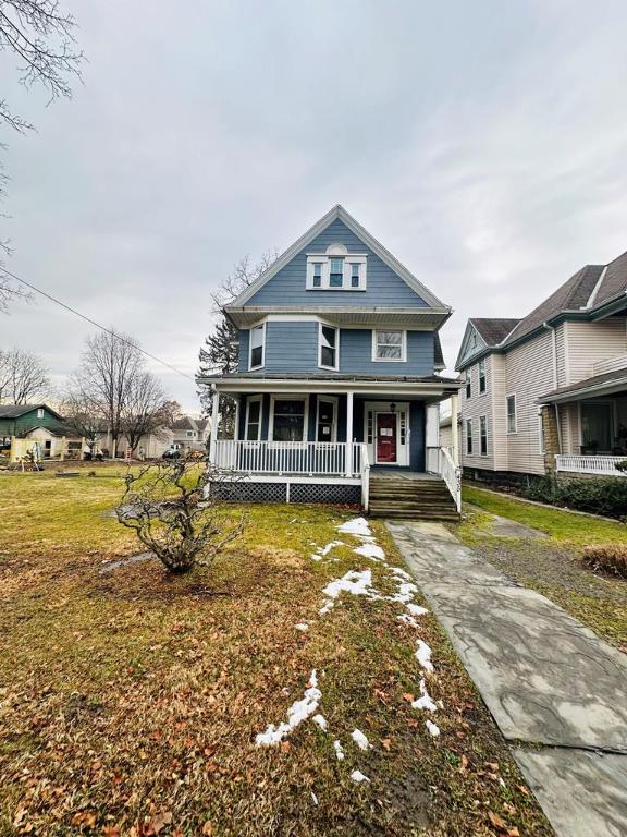 view of front of home with a front yard and covered porch