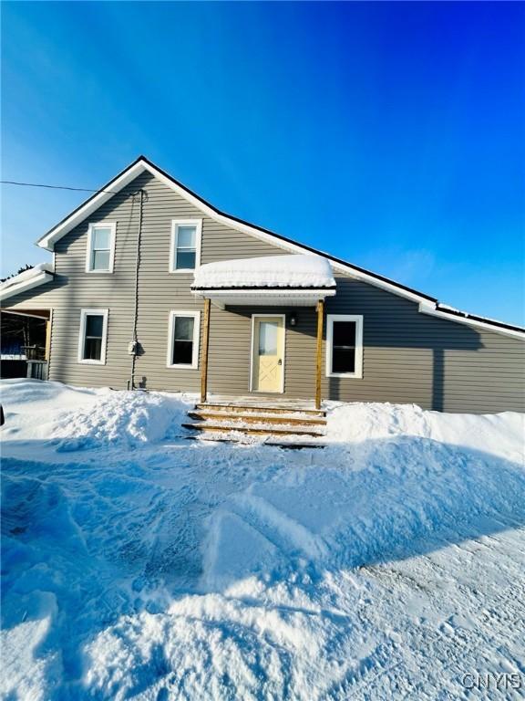 view of snow covered rear of property