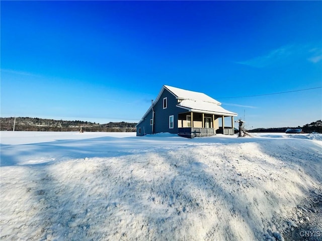 view of snowy exterior featuring a porch