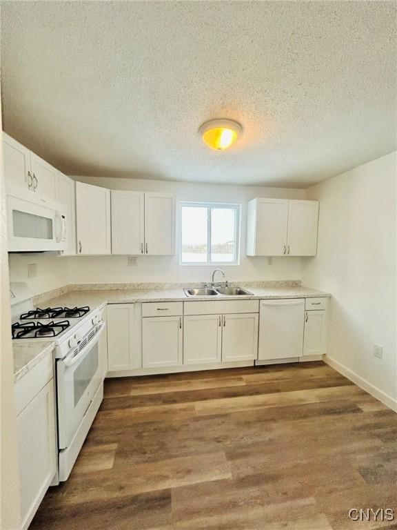 kitchen featuring sink, white cabinets, white appliances, and light hardwood / wood-style flooring