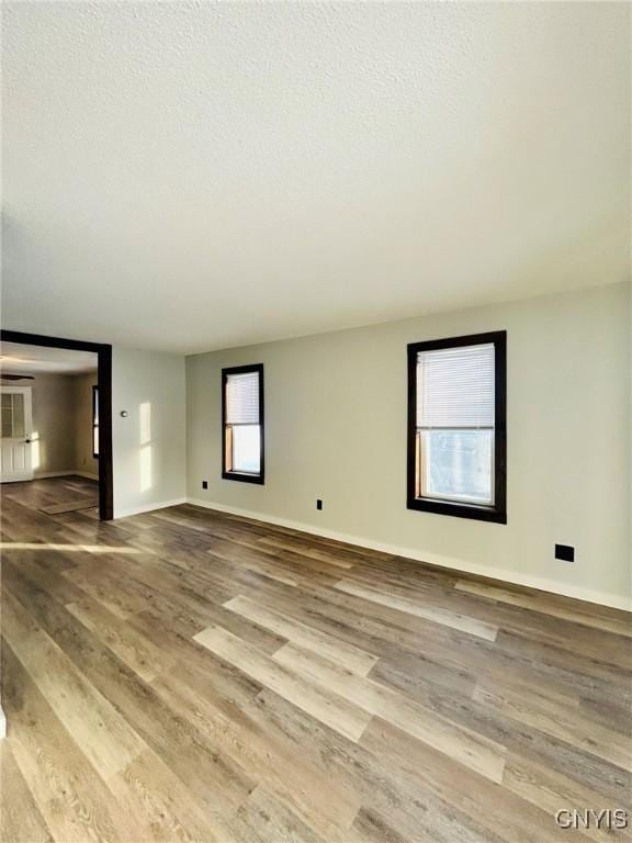 unfurnished room with hardwood / wood-style floors and a textured ceiling