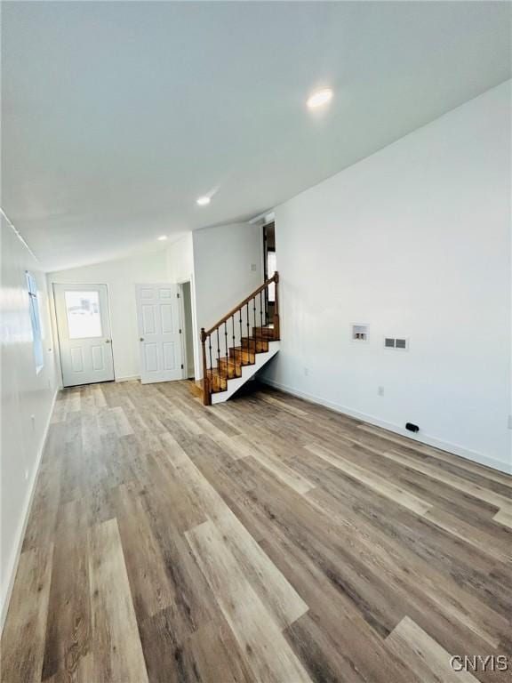 unfurnished room featuring vaulted ceiling and light wood-type flooring