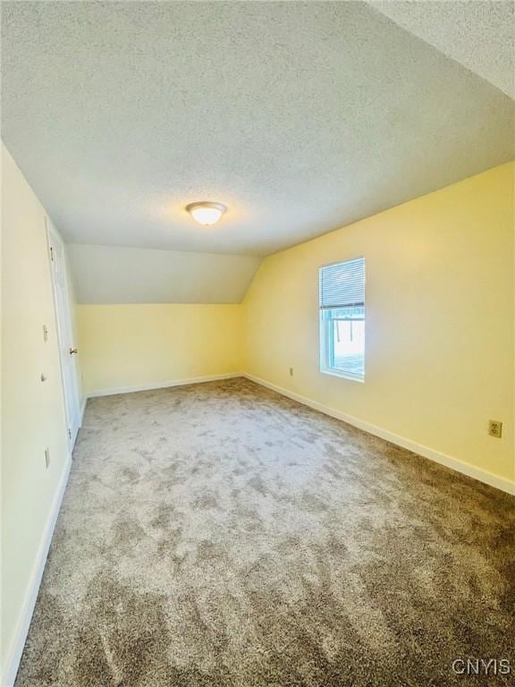 bonus room with vaulted ceiling, carpet, and a textured ceiling