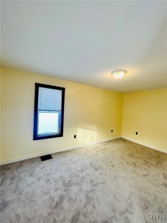 carpeted empty room with a textured ceiling