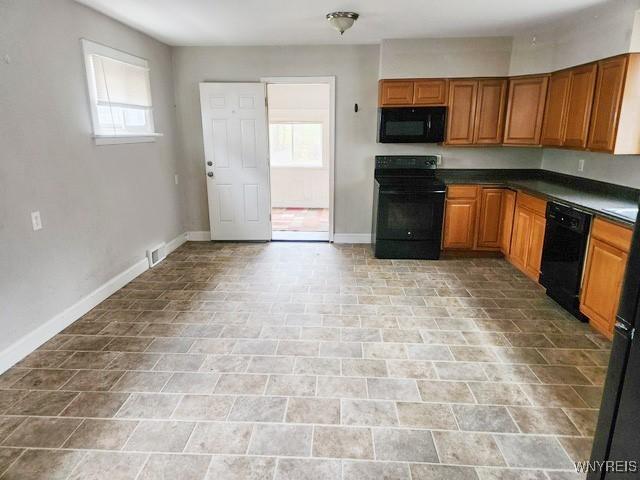 17 Beattie Ave, Lockport-City, NY 14094 - kitchen with dark countertops, brown cabinets, black appliances, and baseboards