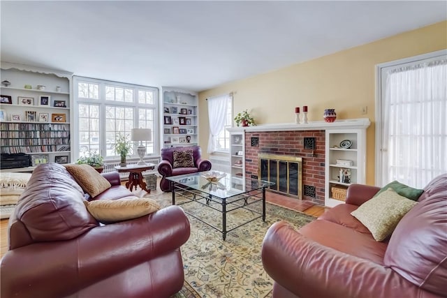 living room featuring hardwood / wood-style flooring, built in features, and a fireplace