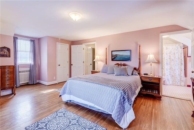 bedroom with radiator and light hardwood / wood-style floors