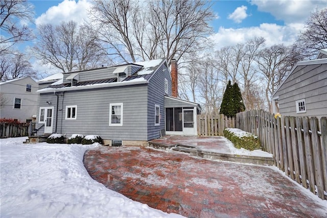 view of snowy exterior featuring a sunroom