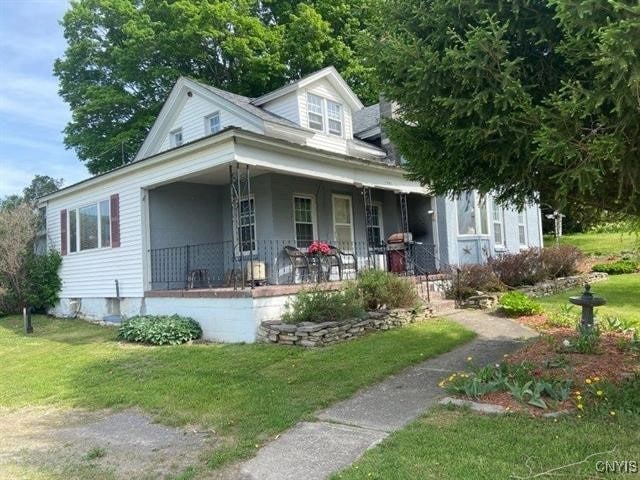 view of front of home featuring covered porch and a front yard