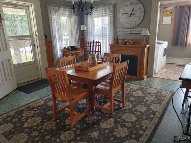 dining room featuring washer and dryer and a notable chandelier