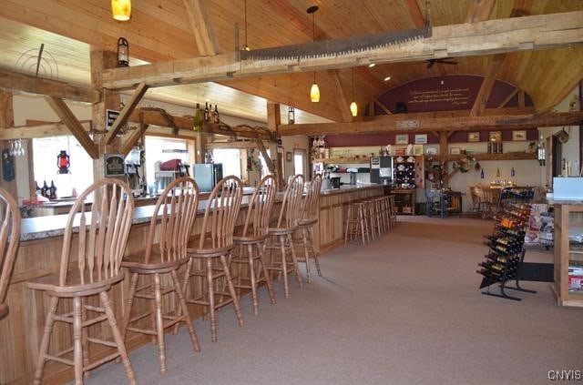 bar with lofted ceiling with beams and carpet flooring