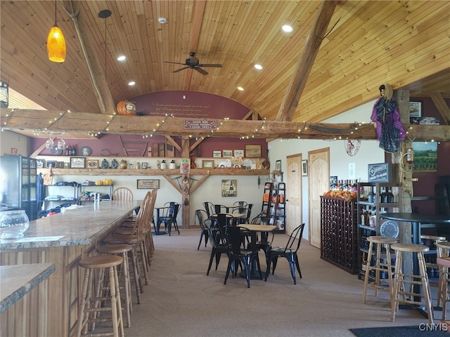 dining room featuring bar, lofted ceiling with beams, and wooden ceiling