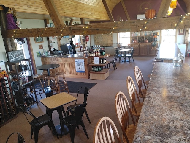 dining space featuring wood ceiling, indoor bar, and vaulted ceiling with beams