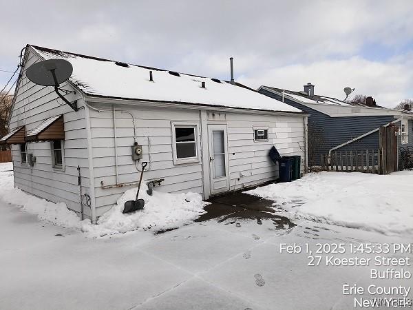 view of snow covered back of property