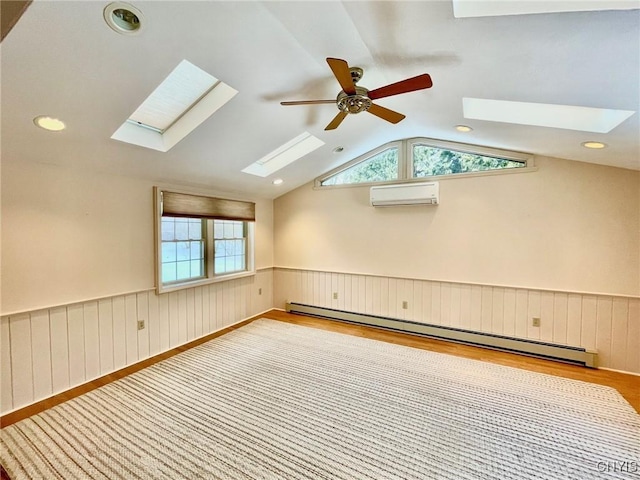 spare room featuring lofted ceiling, a baseboard radiator, a wall unit AC, and light hardwood / wood-style flooring