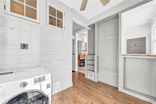 clothes washing area featuring ceiling fan, washer / dryer, ornamental molding, and light wood-type flooring