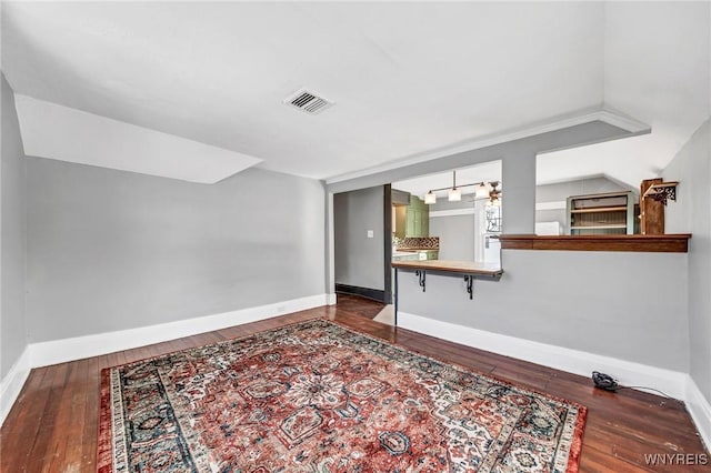 interior space with dark wood-type flooring and vaulted ceiling