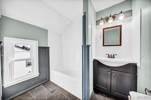 bathroom featuring tile patterned flooring, vanity, vaulted ceiling, and shower / washtub combination