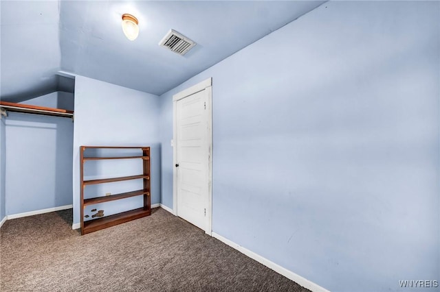 interior space with carpet flooring, vaulted ceiling, and a closet