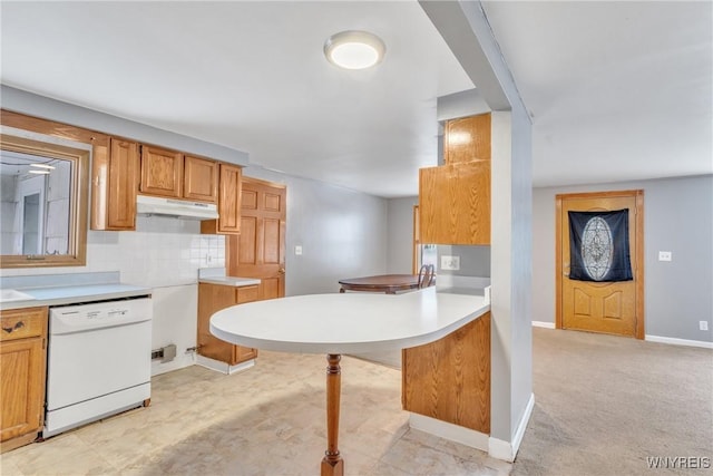 kitchen featuring a breakfast bar, tasteful backsplash, light carpet, white dishwasher, and kitchen peninsula