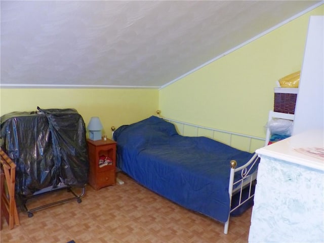 bedroom featuring vaulted ceiling, ornamental molding, and parquet floors