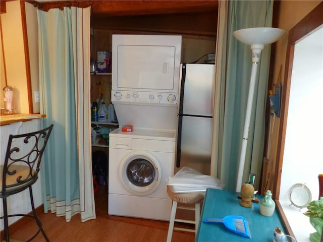 clothes washing area featuring stacked washer / drying machine and light wood-type flooring