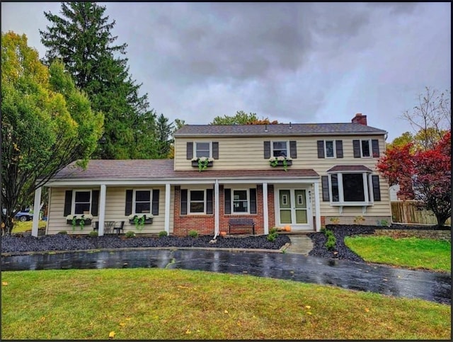 colonial house featuring a front lawn