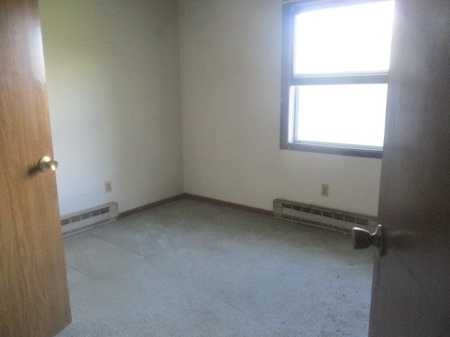 spare room with baseboard heating and carpet floors