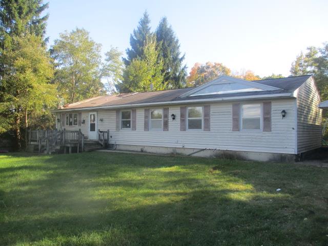 view of front facade featuring a front yard and a deck