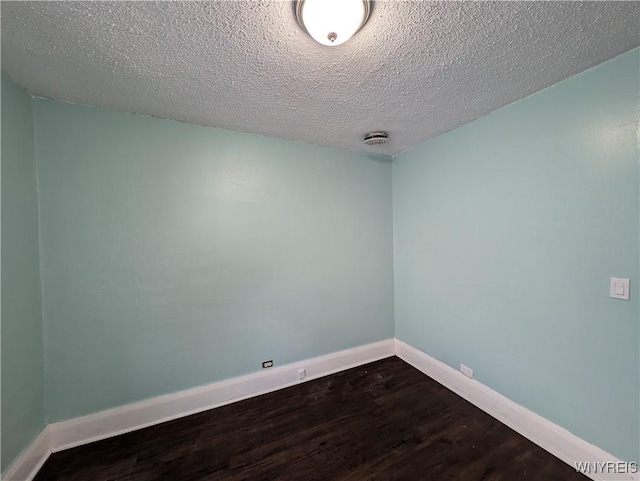 empty room with hardwood / wood-style floors and a textured ceiling