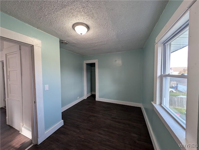 unfurnished room featuring dark hardwood / wood-style floors and a textured ceiling