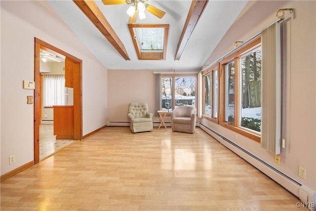 interior space with ceiling fan, a baseboard radiator, and lofted ceiling with skylight