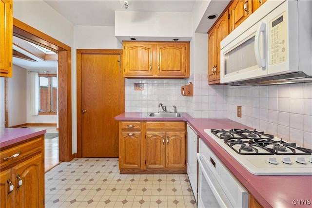 kitchen featuring tasteful backsplash, white appliances, and sink