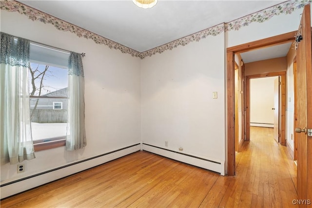 spare room featuring hardwood / wood-style flooring and baseboard heating