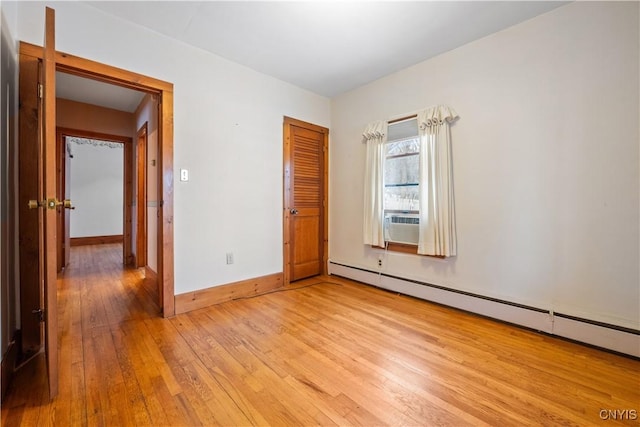 unfurnished bedroom with a baseboard radiator, a closet, and light hardwood / wood-style flooring