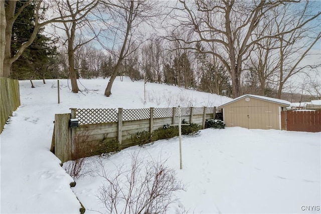 yard covered in snow with a storage unit