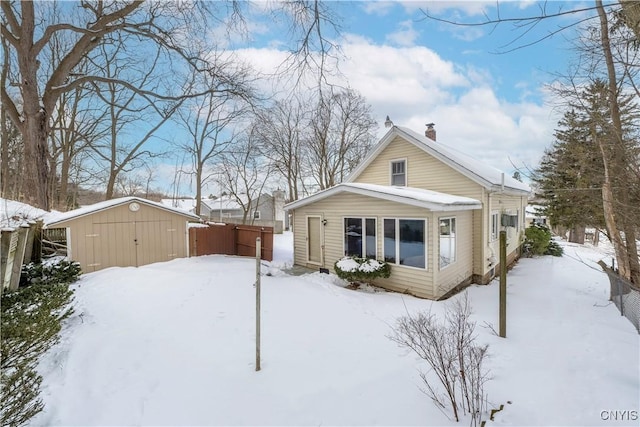 snow covered house with a storage unit