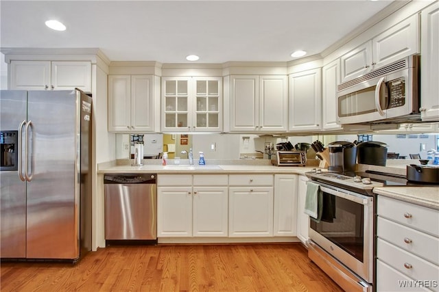 kitchen with white cabinetry, sink, stainless steel appliances, and light wood-type flooring