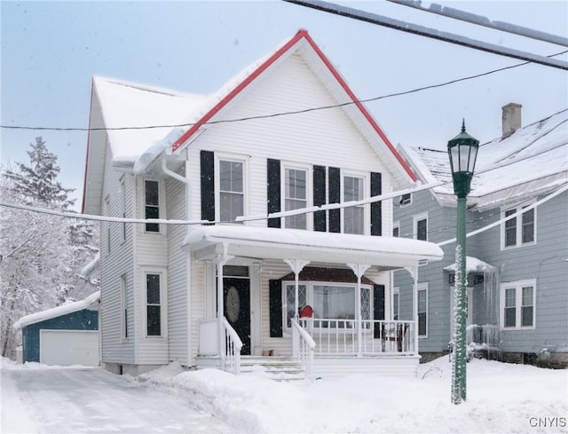 view of front of home featuring an outbuilding, a garage, and covered porch