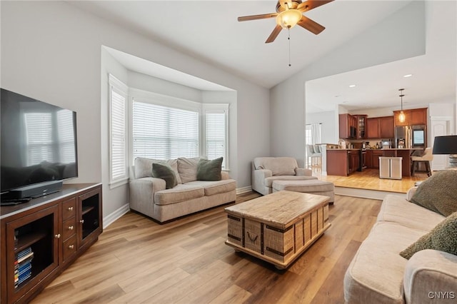 living room featuring vaulted ceiling, ceiling fan, and light wood-type flooring