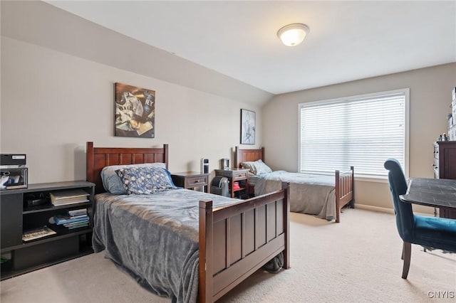 bedroom with radiator heating unit, vaulted ceiling, and light carpet