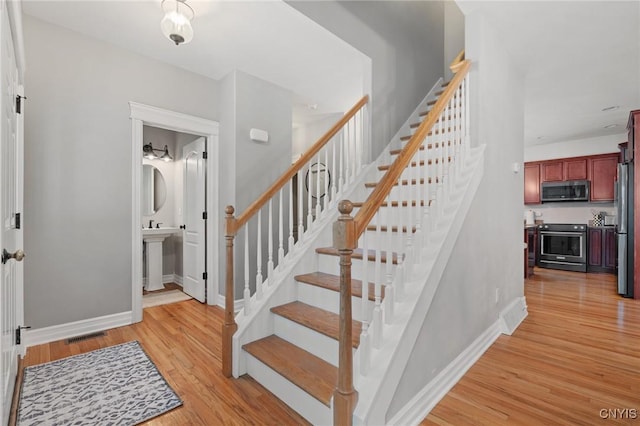 staircase featuring sink and wood-type flooring