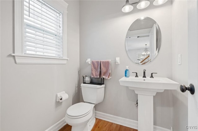 bathroom with wood-type flooring, toilet, and sink