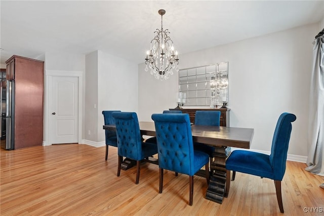 dining space featuring a notable chandelier and light hardwood / wood-style flooring