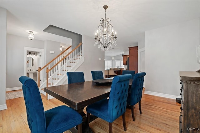 dining space featuring a notable chandelier and light wood-type flooring