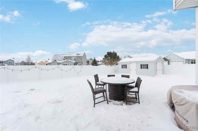 yard layered in snow with an outbuilding