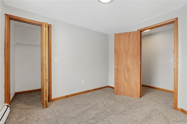 unfurnished bedroom with light carpet, a baseboard heating unit, a spacious closet, and a closet